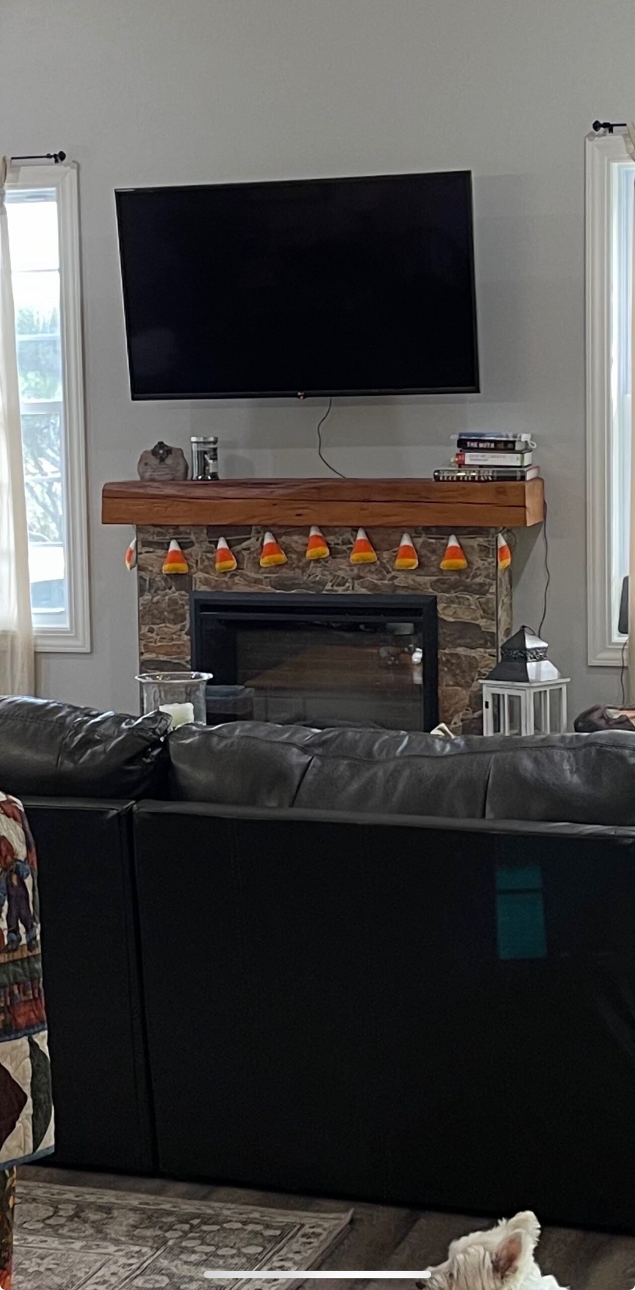 Living room with wall-mounted TV above a wood fireplace mantel