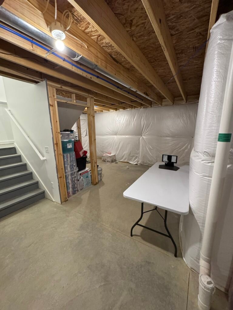Unfinished basement area beside the stairs before framing