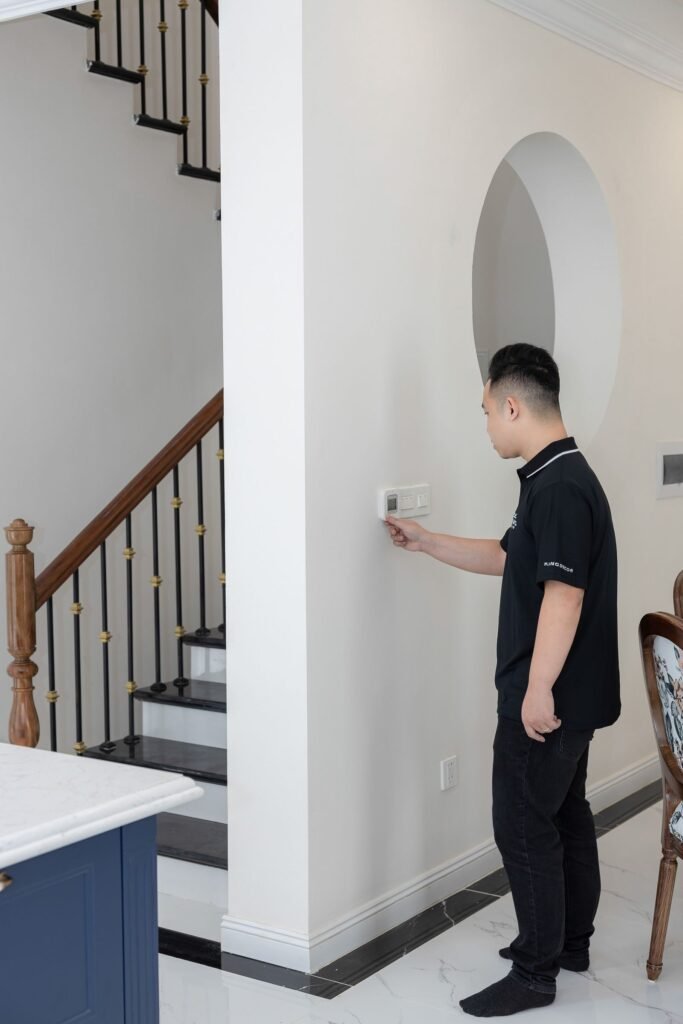 Man adjusting a wall-mounted smart thermostat at home